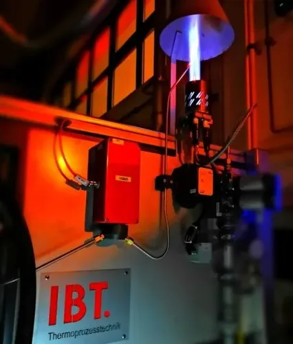 Das Bild zeigt eine thermische Nachverbrennungsanlage der Firma IBT Thermprocess aus Freiberg für industrielle Anwendungen, welche die sichere thermische Nachbehandlung von Prozessgasen aus einem wasserstoffbetriebenen Vakuumofen ermöglicht.