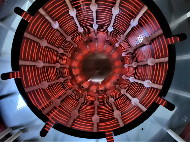 Das Bild zeigt den Heizraum eines Vakuumofens aus Edelstahl mit Molybdänheizern der Firma IBT Thermprozesse aus Freiberg. Der Ofen schafft Temperaturen von bis zu 1.600 °C.