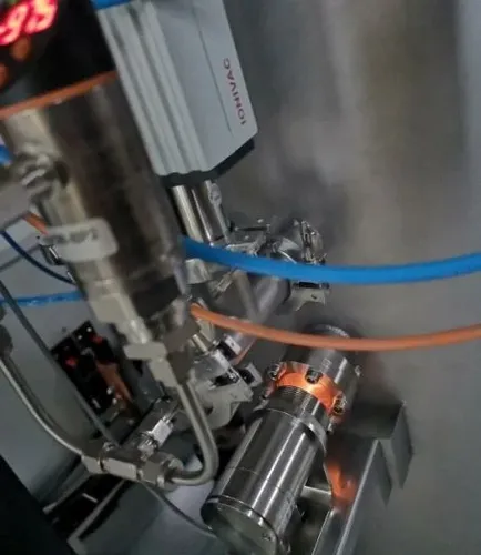 Das Bild zeigt ein Pyrometer der Firma IBT Thermprocess aus Freiberg zur berührungslosen Temperaturmessung im Ofenraum, das vor einem vakuumdichten Flansch mit Schauglas installiert ist.