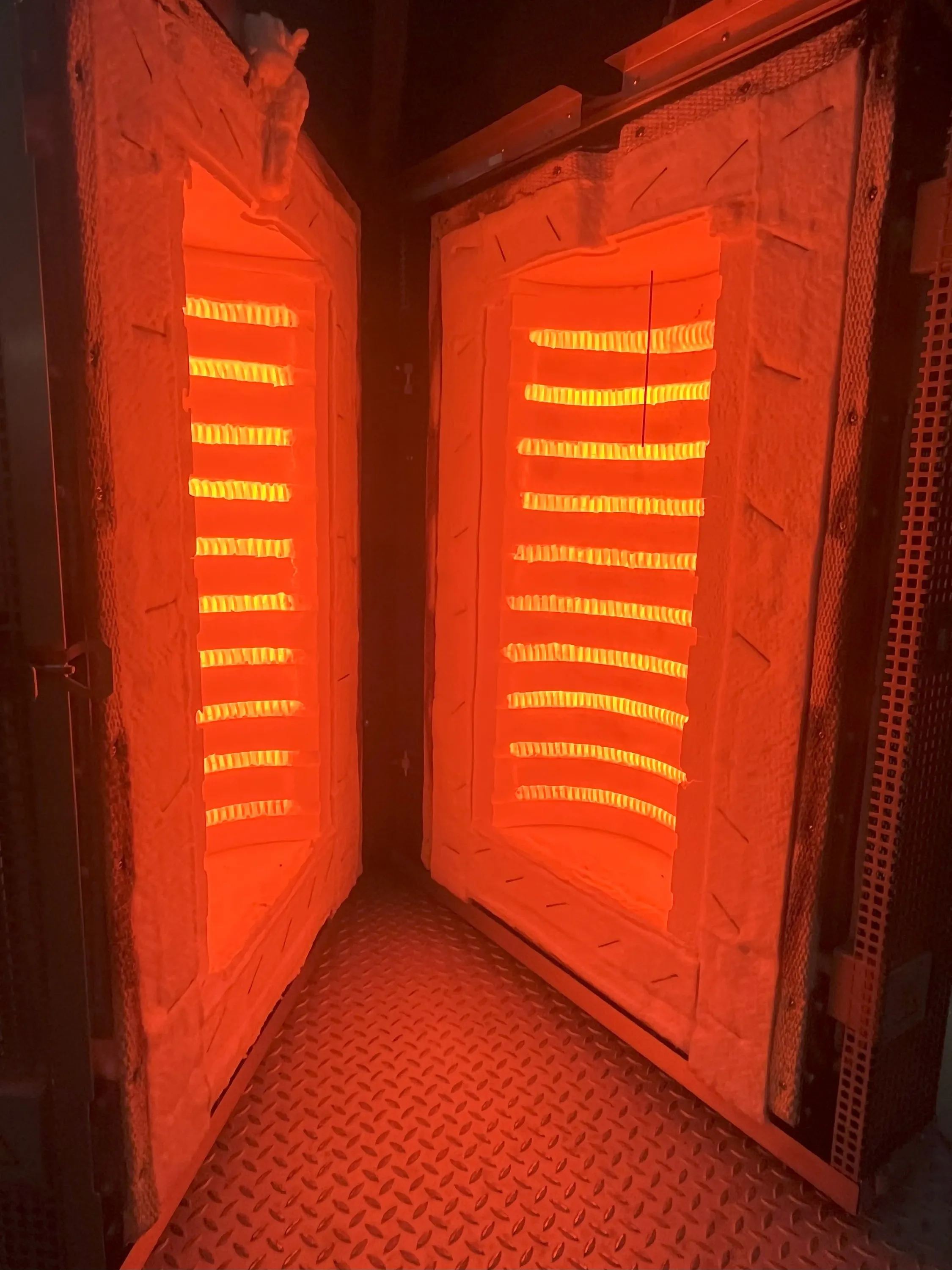 Das Bild zeigt einen klappbaren Muffelofen der Firma IBT Thermprocess aus Freiberg für industrielle Anwendungen, welcher zur Beheizung einer Retorte für Wasserstoffprozesse bei Temperaturen bis 1200 °C eingesetzt wird.